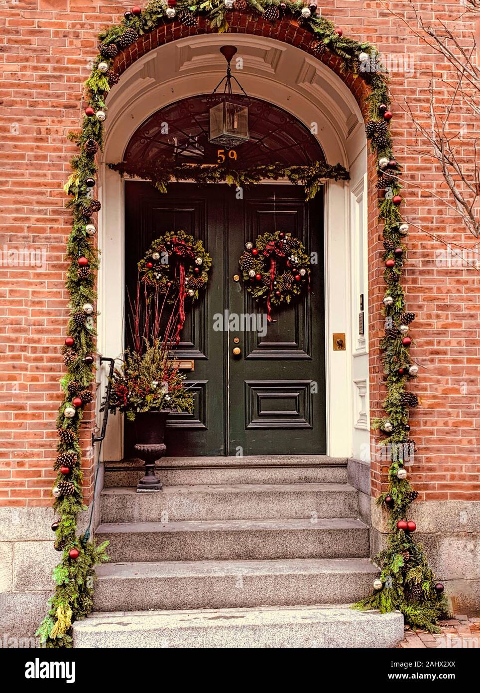 Christmas holiday wreaths hanging on doors and windows in a historic town. Stock Photo