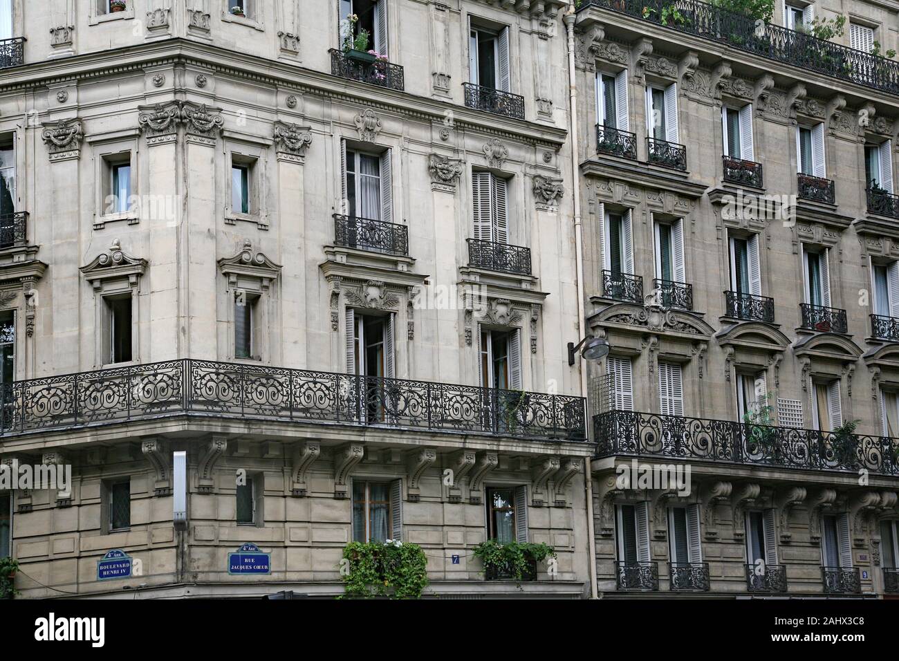 Paris, typical old apartment building with wrought iron balcony railings and planters Stock Photo