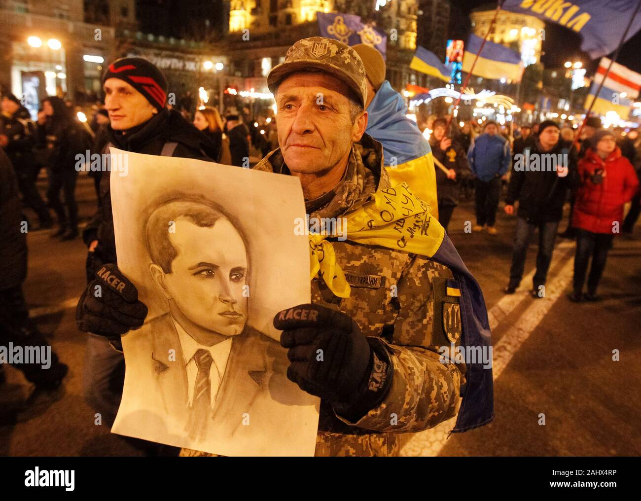 Ukrainian far-right activist with a portrait of Stepan Bandera during the march.Ukrainian nationalists walked through the streets with torches in an annual torch march marking the 111th birthday of Stepan Bandera, leader of the Ukrainian nationalist movement. Stock Photo