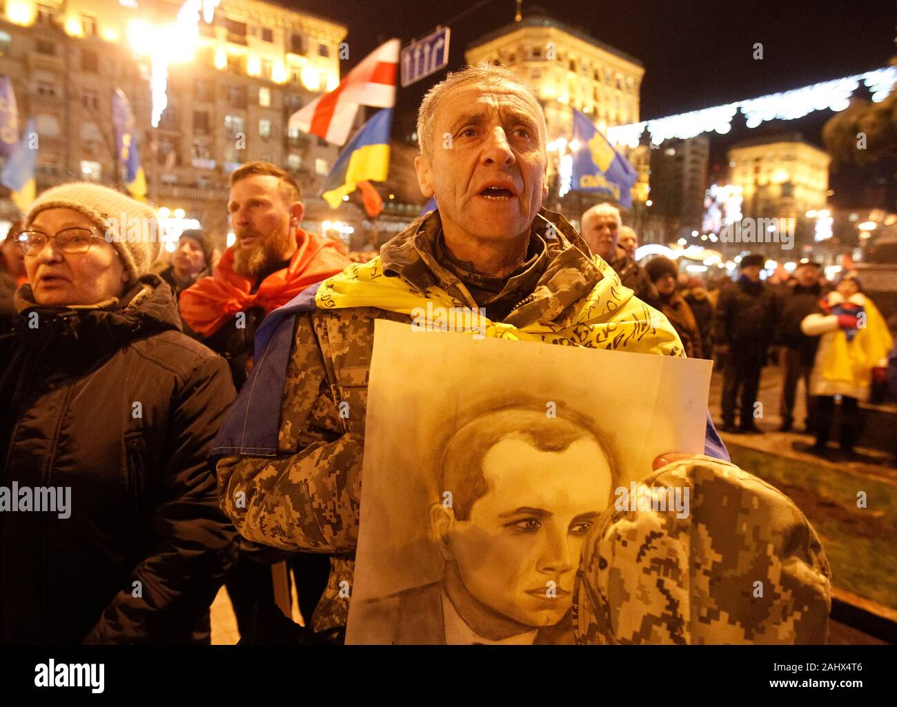 Ukrainian far-right activist with a portrait of Stepan Bandera during the march.Ukrainian nationalists walked through the streets with torches in an annual torch march marking the 111th birthday of Stepan Bandera, leader of the Ukrainian nationalist movement. Stock Photo