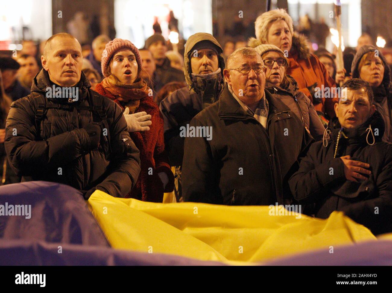 Ukrainian activists sing the Ukrainian anthem during a rally of ...