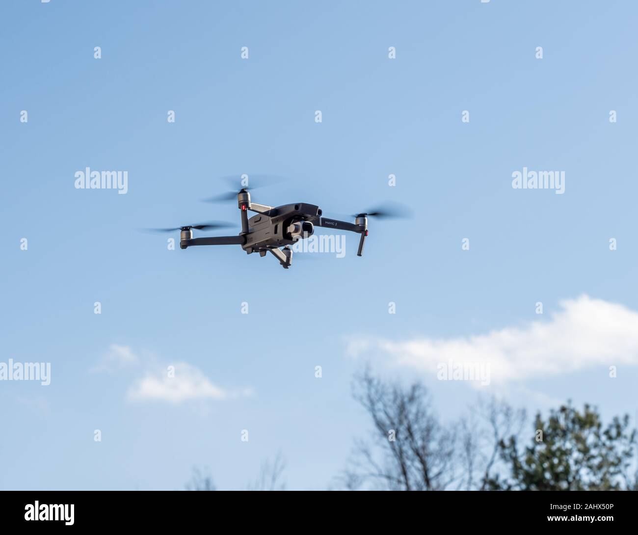 Morgantown, WV - 1 January 2020: DJI Mavic 2 Pro quadcopter or drone hovering in bright blue sky Stock Photo