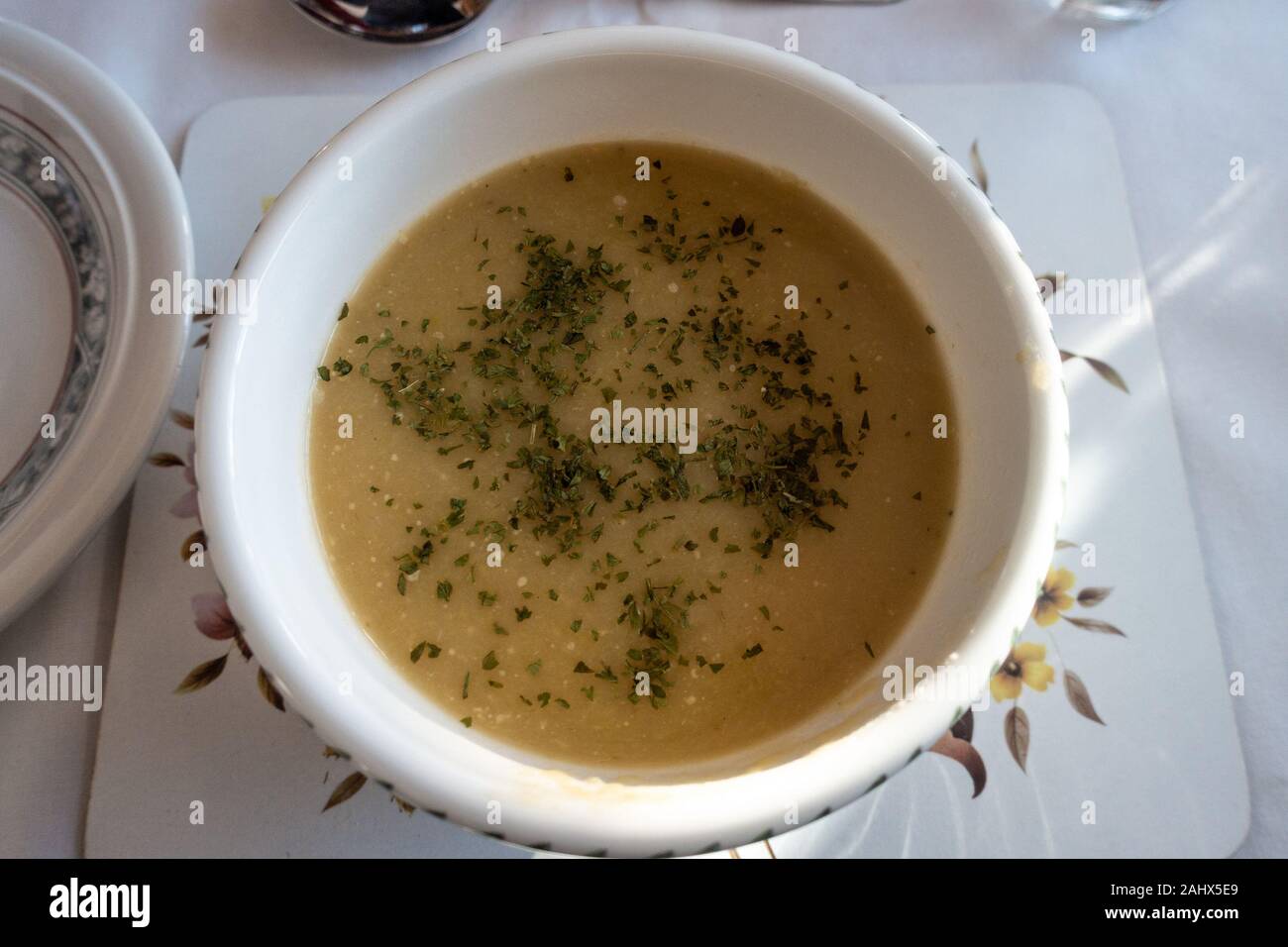 A bowl of homemade leek and potato soup garnished with s sprinkle of parsley. Stock Photo