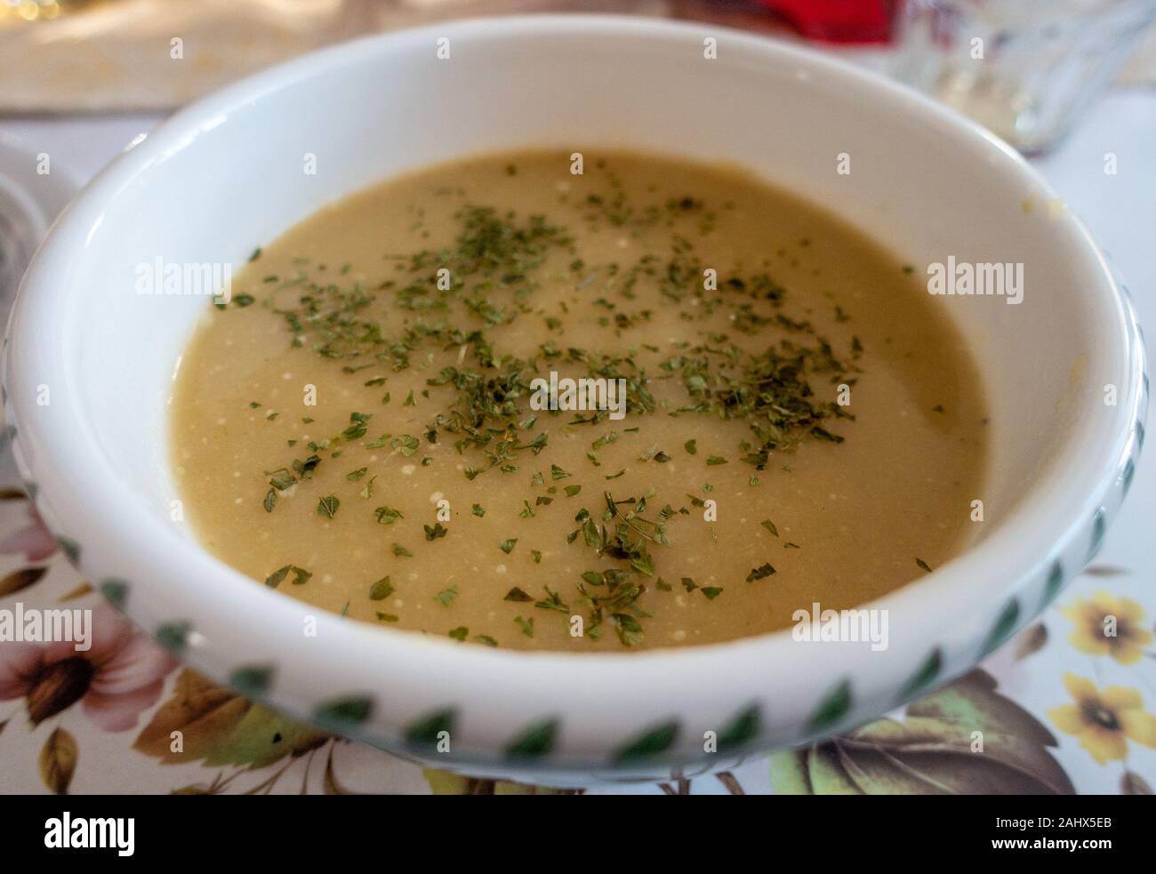 A bowl of homemade leek and potato soup garnished with s sprinkle of parsley. Stock Photo