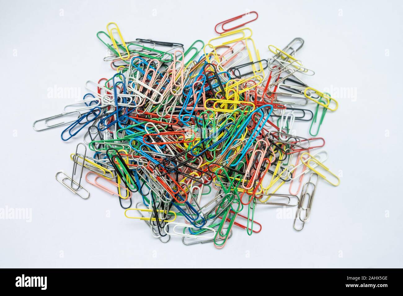 A pile of paper clips against a white background. Stock Photo