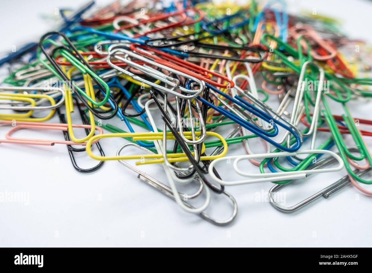 A pile of paper clips against a white background. Stock Photo
