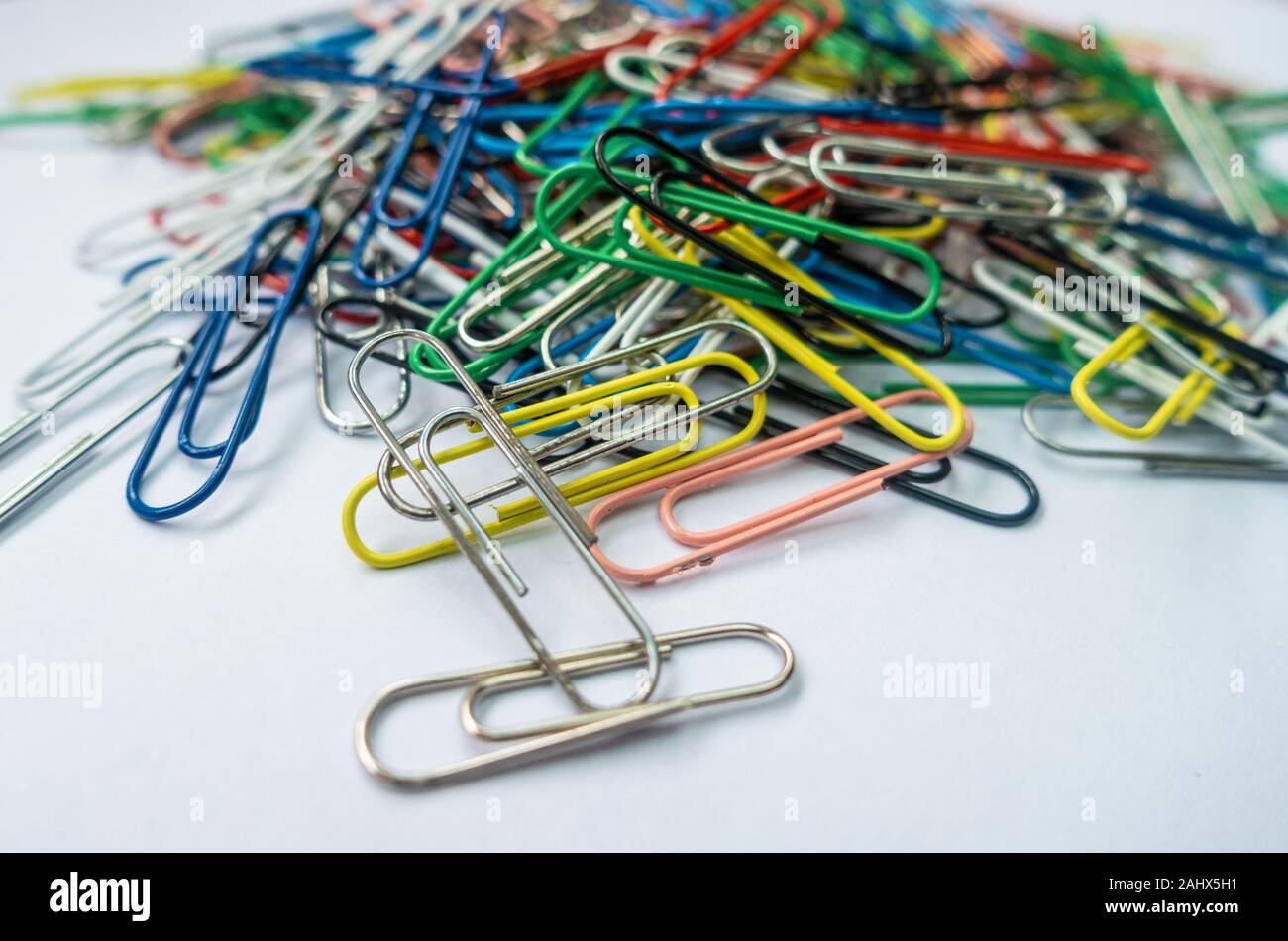 A pile of paper clips against a white background. Stock Photo