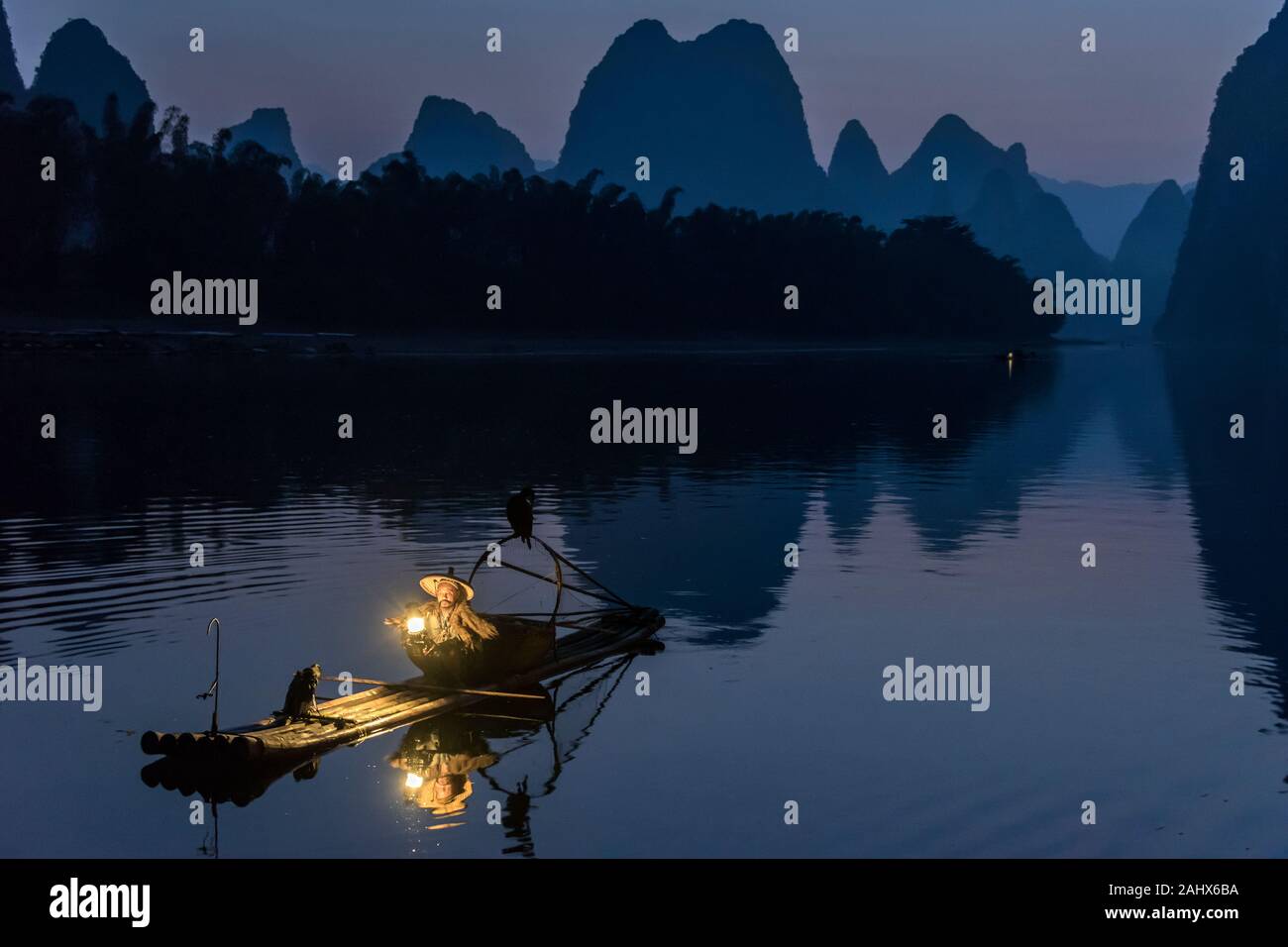 Cormorant fisherman preparing his lantern at dawn, Li River, Xingping, Guilin, China Stock Photo