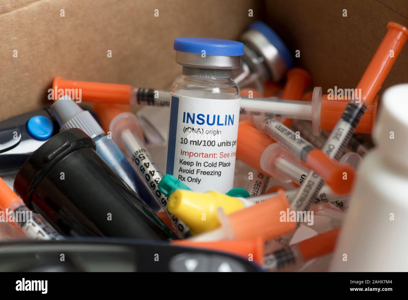 Insulin vial with syringes, test strips and other diabetic medical supplies in mailing postal box. Stock Photo