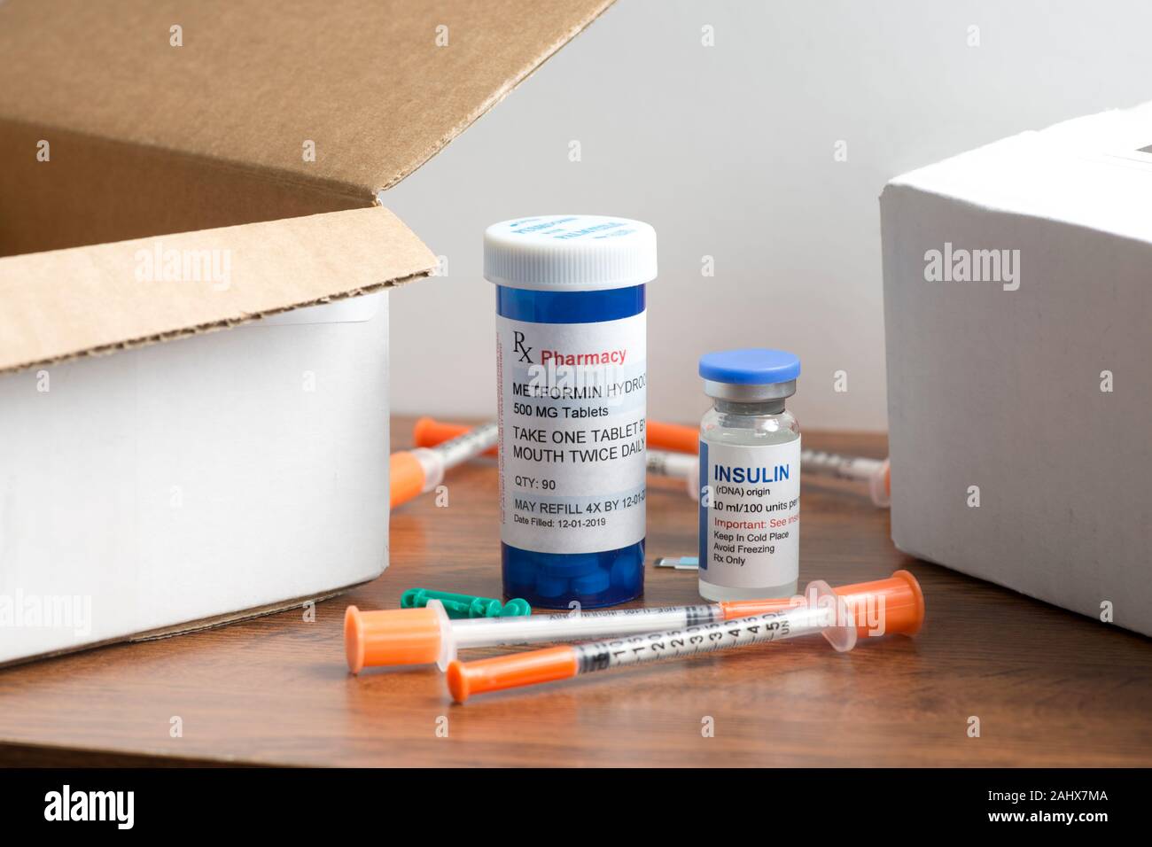 Insulin vial and Metformin Hydrochloride prescription bottle with syringes, test strips and other diabetic medical supplies and mailing postal boxes. Stock Photo