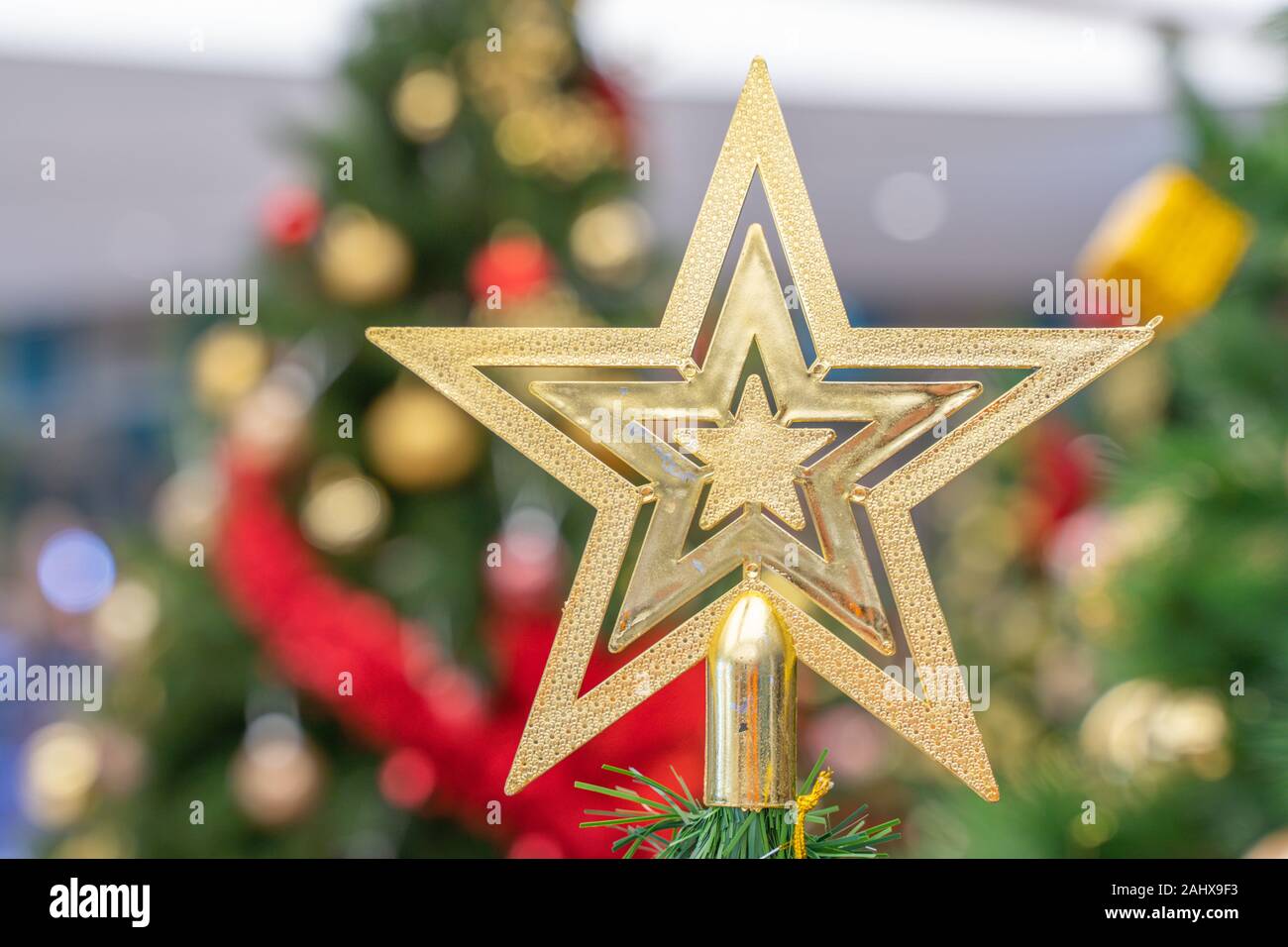 Beautiful Christmas star hanging from a decorated Christmas tree Stock Photo