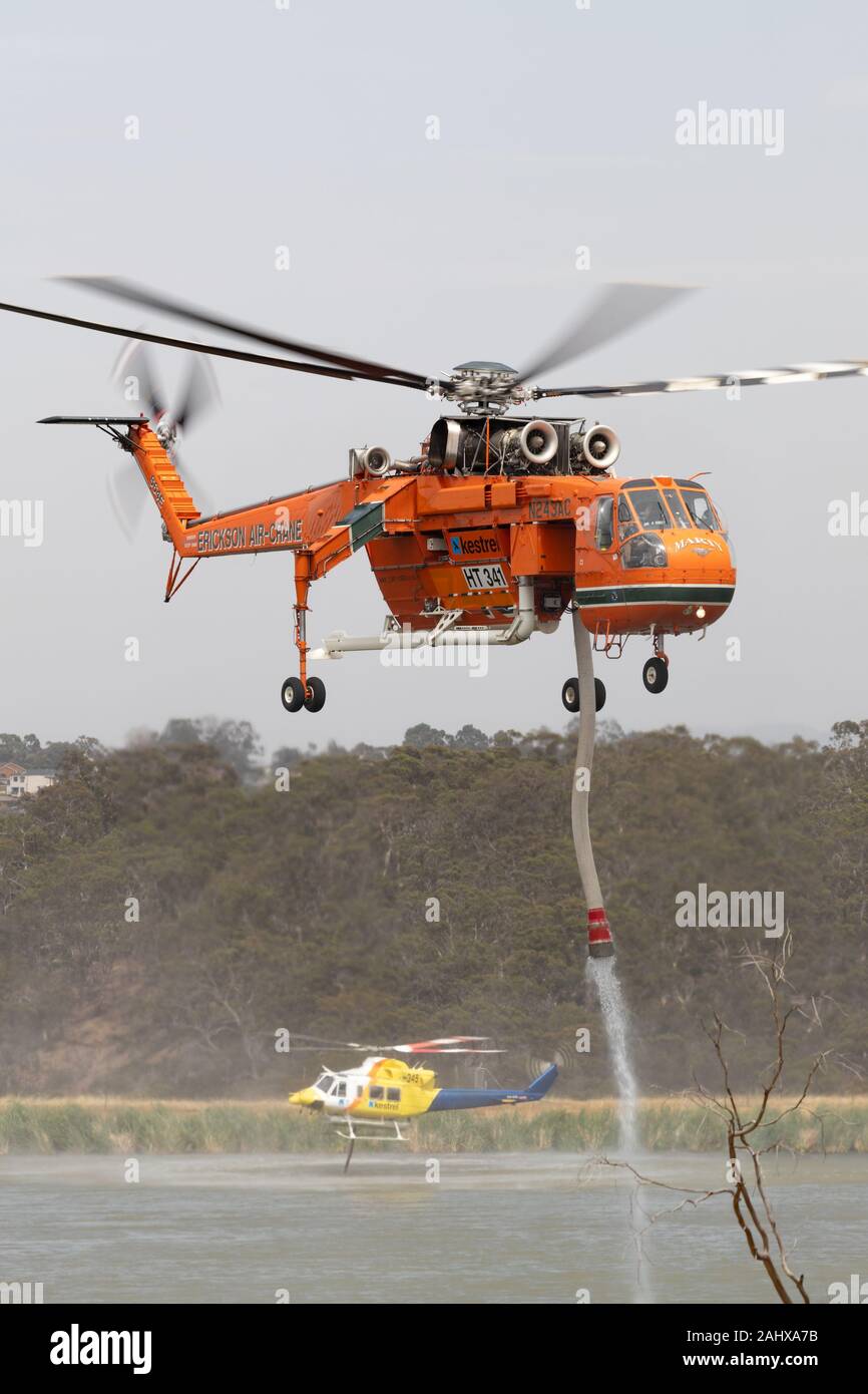 Erickson Air Crane helicopter taking off after filling with a load of water to fight a fire. Stock Photo