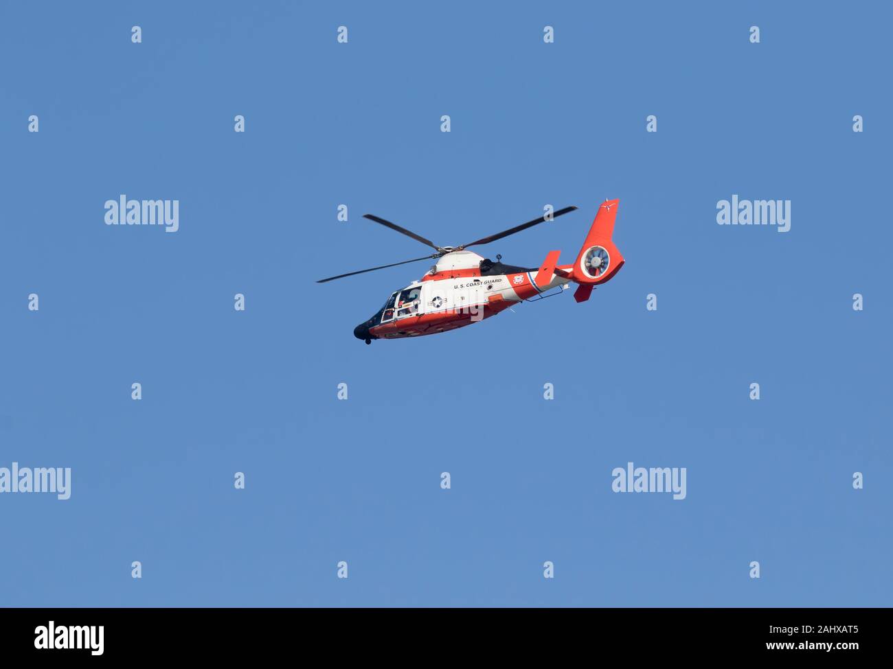 The coast guard helicopter flying in the blue sky over ocean, Galveston ...