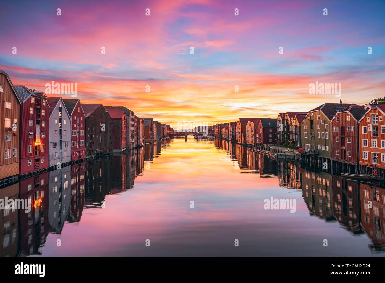 View of colorful timber houses surrounding river Nidelva in the city of Trondheim at sunset. View from Old Town Bridge. Trondelag county. Norway Stock Photo