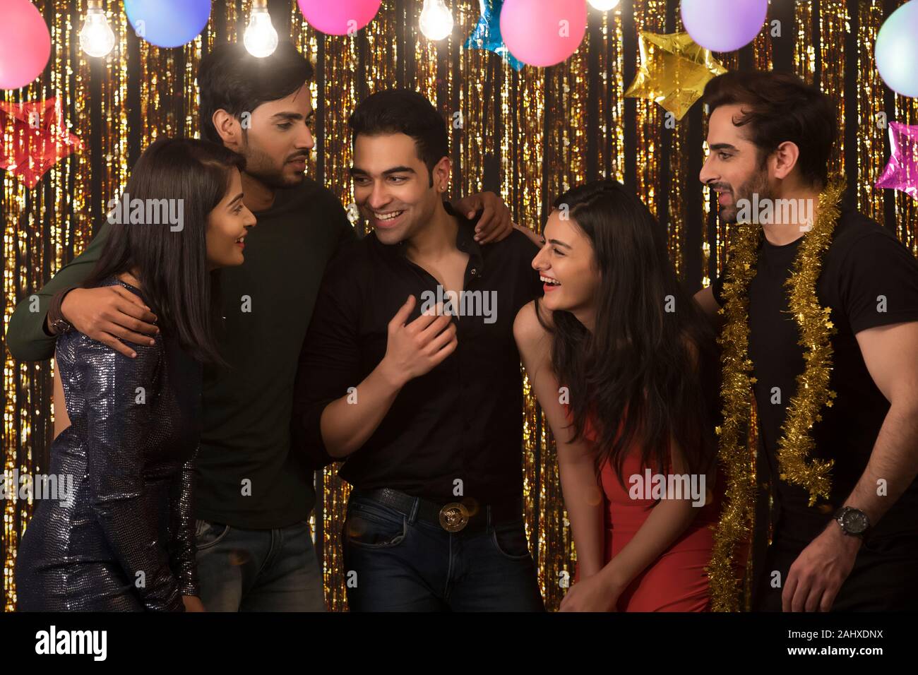 Group of friends talking with each other at a new year eve party. Stock Photo