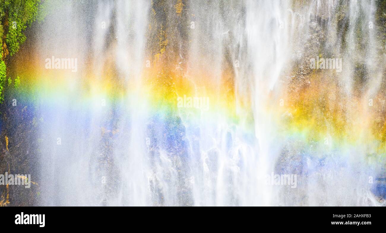 Close-up view of the Tumpak Sewu Waterfalls also known as Coban Sewu with a beautiful rainbow formed by refraction of light in water droplets. Stock Photo