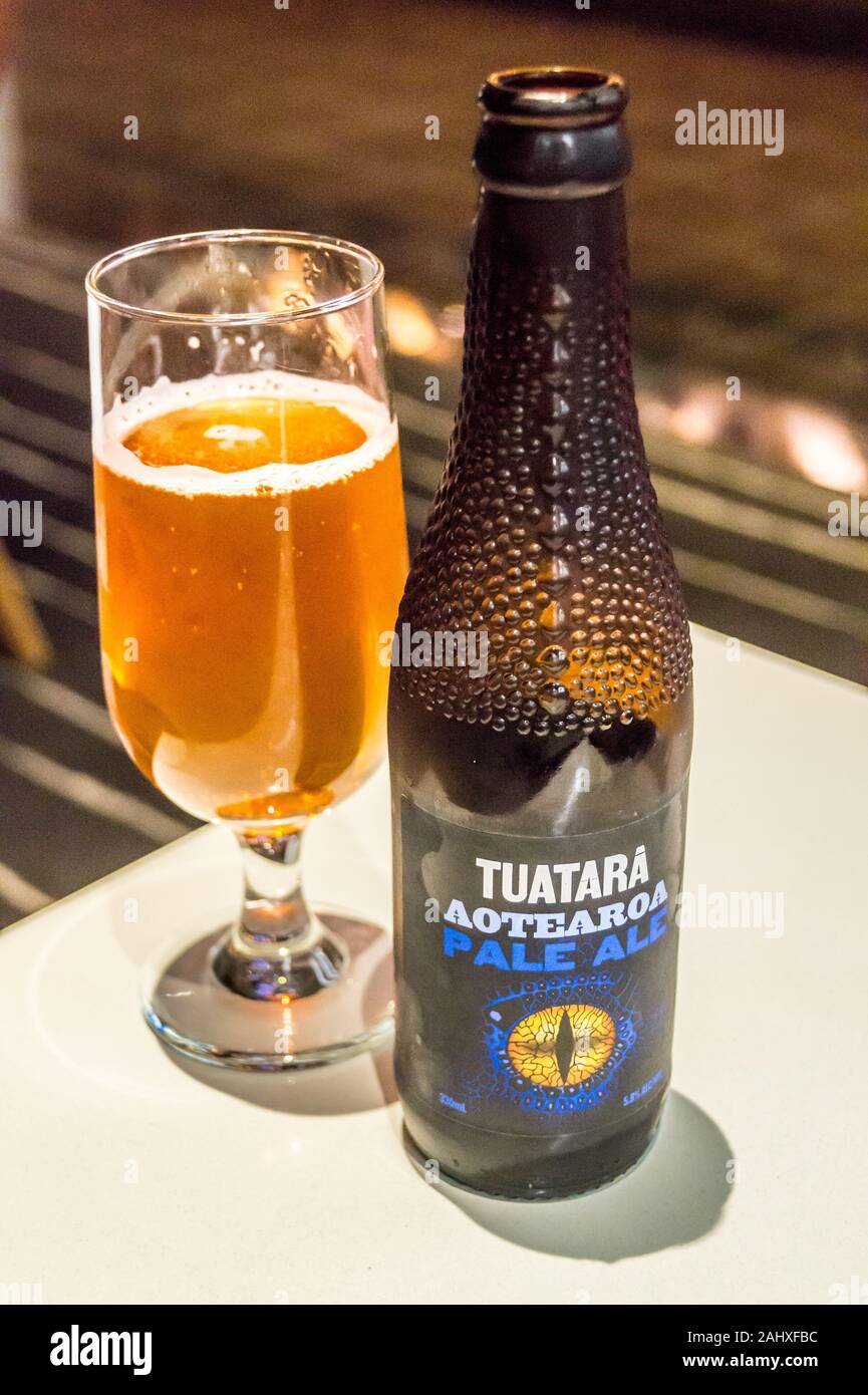 PHOTOGRAPH A glass and bottle of Tuatara Aotearoa Pale Ale in a moulded bottle, Qantas International Business Lounge, Auckland Airport, New Zealand Stock Photo