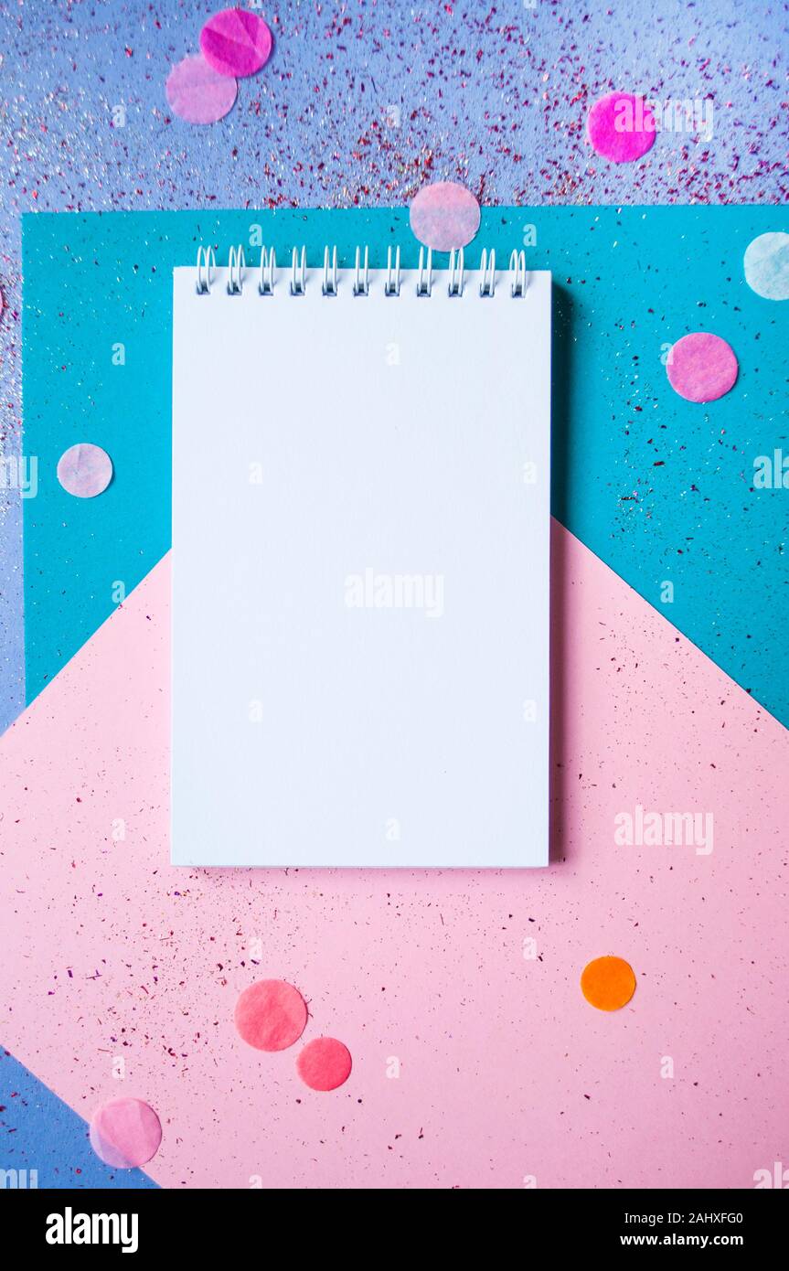 Colorful confetti, sparkles and notebook with wish list on bright