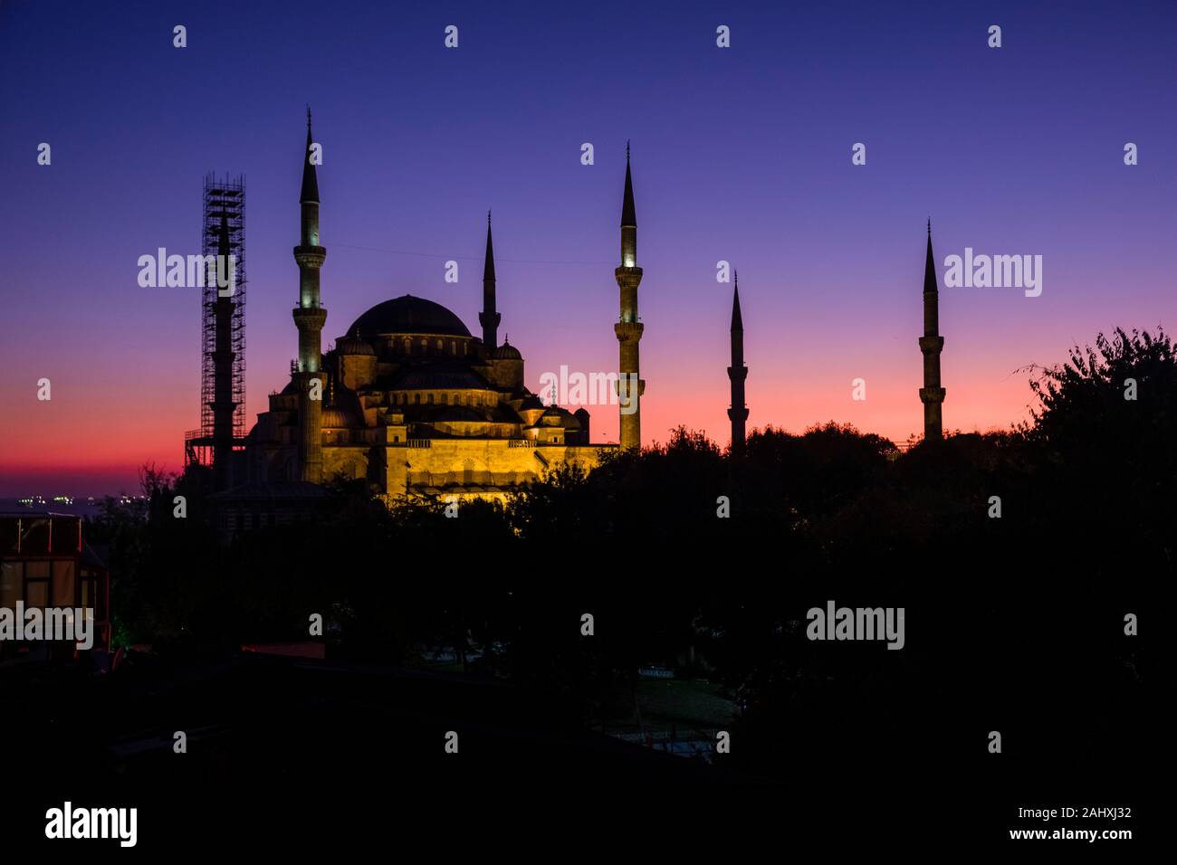 Blue Mosque, Sultan Ahmed Mosque, Sultan Ahmet Camii, with a minaret surrounded by scaffolding, illuminated after sunset Stock Photo