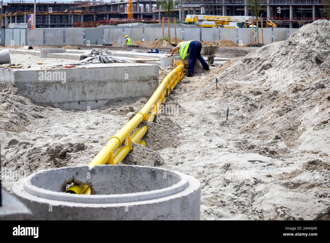 Underground cable duct bank installation. Trench with yellow ducts for