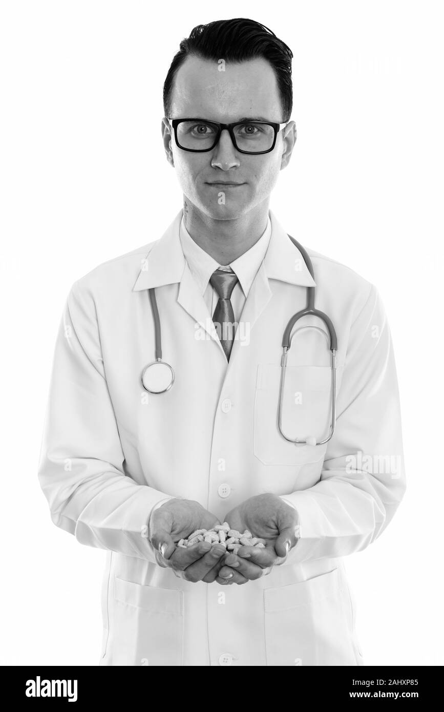 Studio shot of young man doctor holding vitamin tablets with both hands Stock Photo