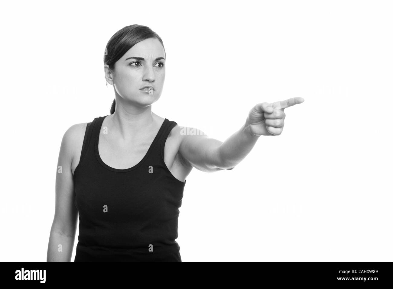 Studio shot of beautiful woman looking angry while pointing finger at distance Stock Photo