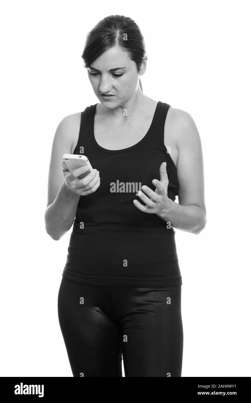 Studio shot of angry woman holding mobile phone Stock Photo