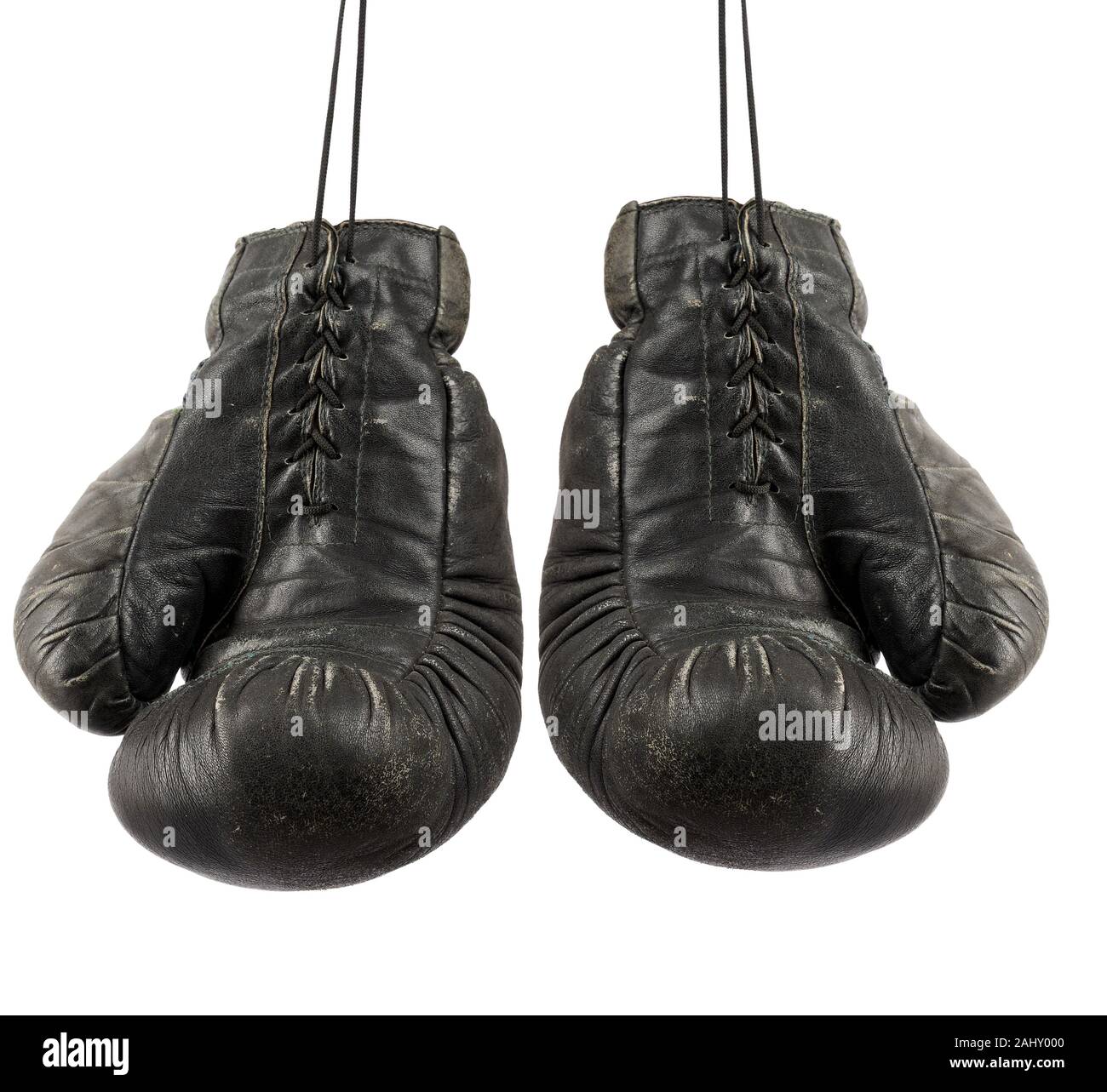 pair of very old vintage black leather boxing gloves hanging on a rope