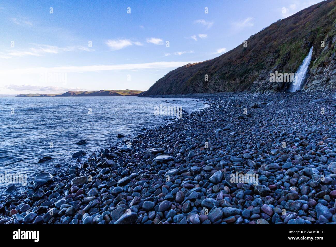 Bucks Mills High Tide View of the Beach With Bright Coloured Wet Pebbles, North Devon Coastline, Waterfall and Bideford Bay ; Bucks Mills, Devon, UK Stock Photo