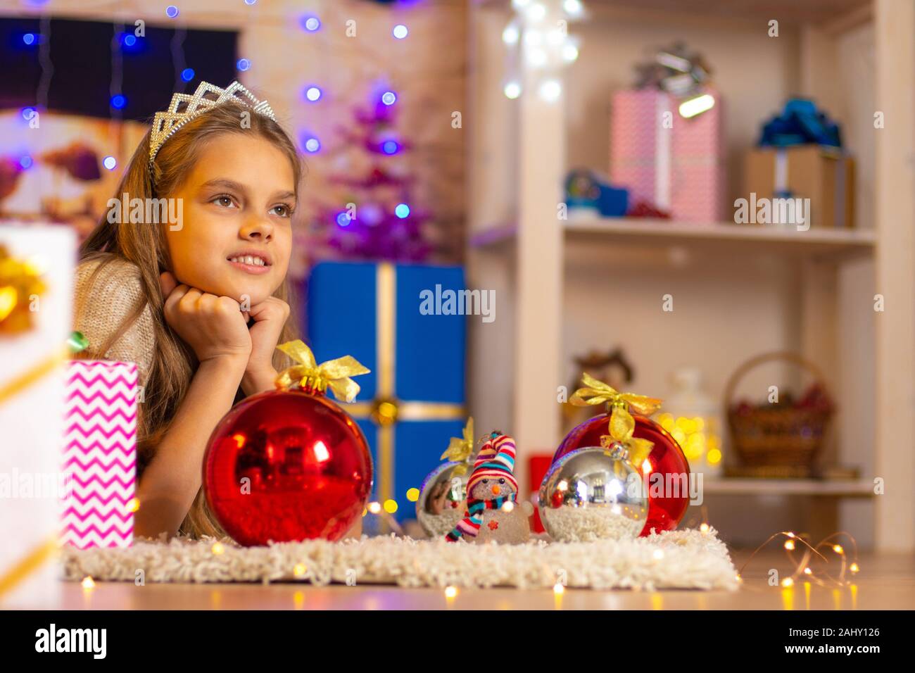 Beautiful tenyearold girl lies on a rug in the New Year's interior
