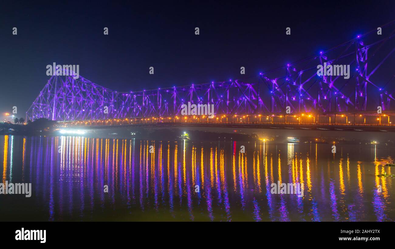 Howrah bridge (selective focus) - The historic cantilever bridge on the river Hooghly lit with purple and yellow lights Stock Photo