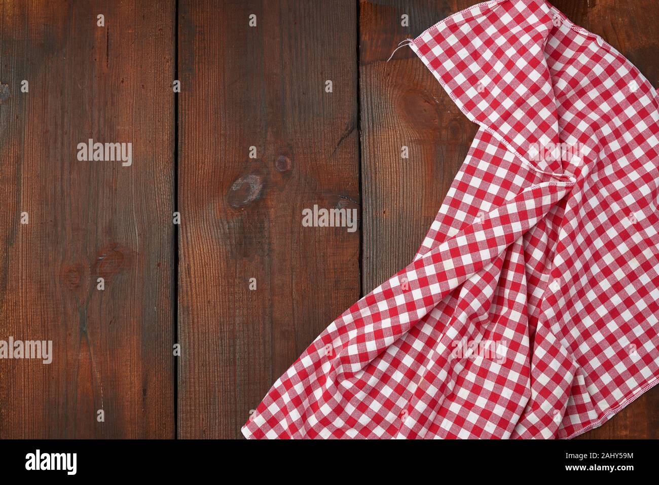 white red checkered kitchen towel on a brown wooden background, picnic
