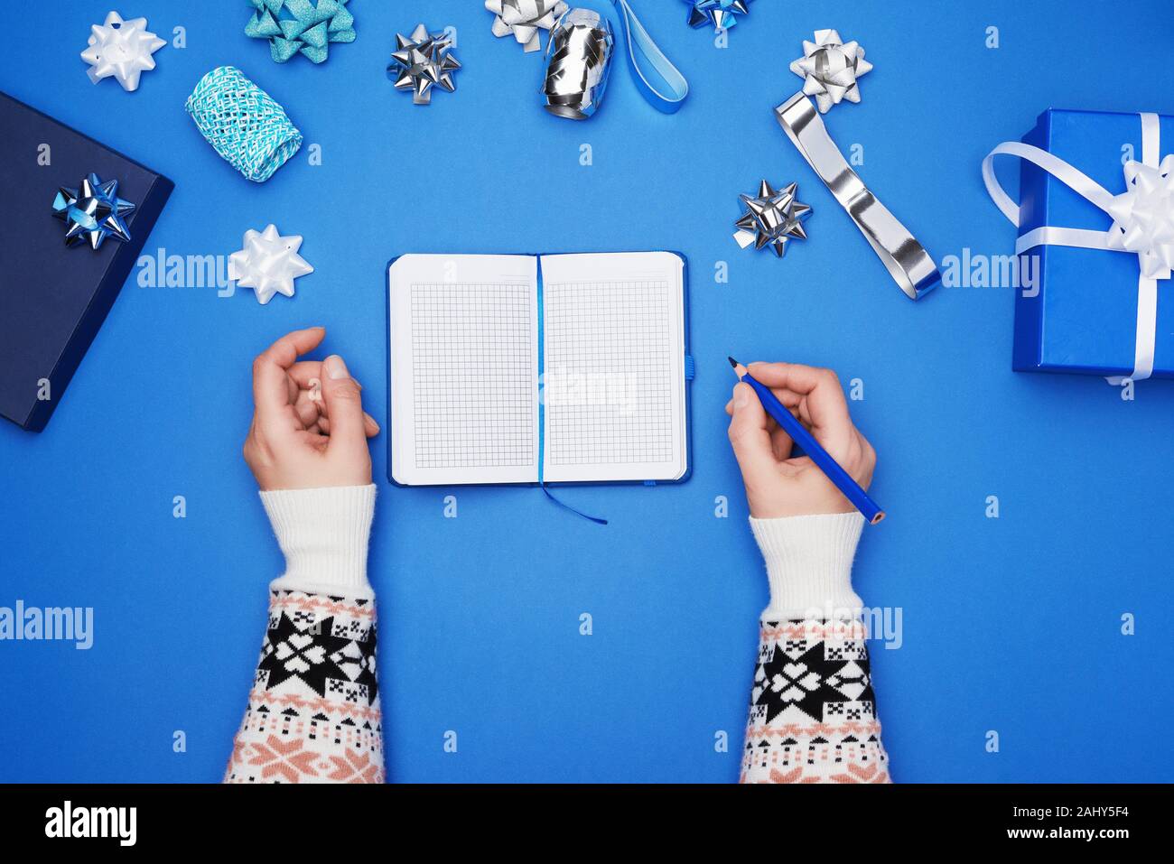 Open Notebook With Empty White Sheets And Two Female Hands Blue