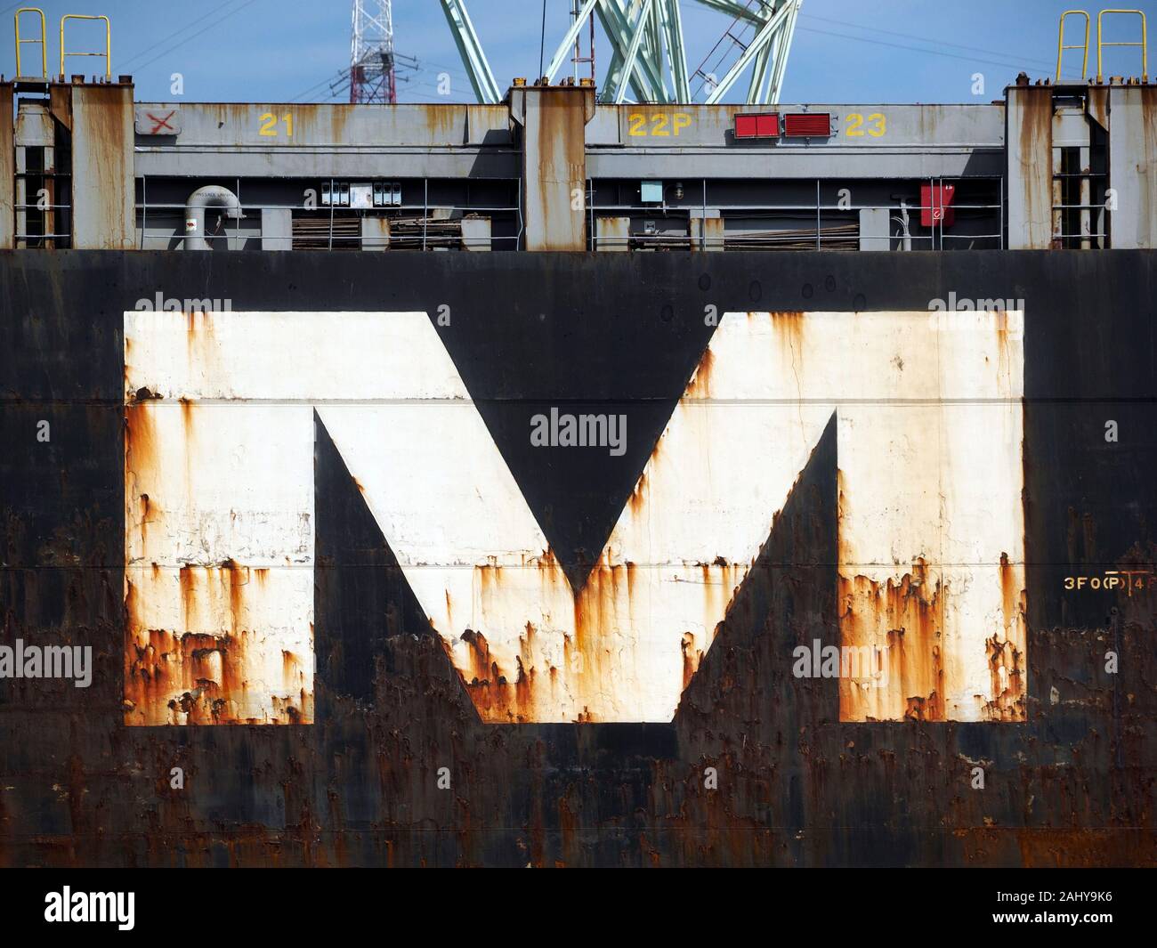 Big rusty capital M letter on hull of ship Stock Photo