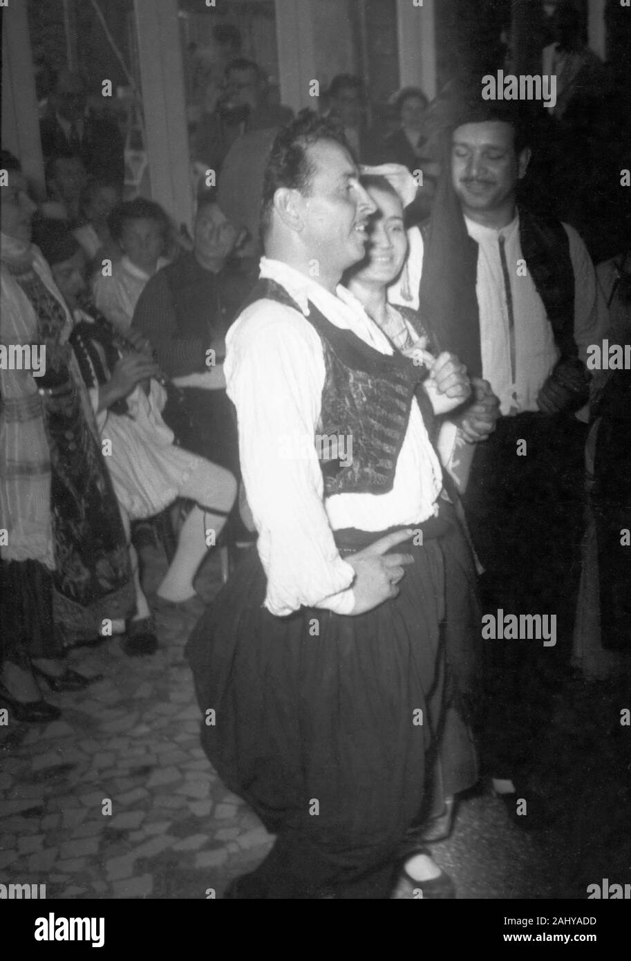 Ein Volkstanz mit traditioneller Kleidung von Einheimischen in Athen, Griechenland 1950er Jahre. A folk dance with traditional clothing of locals in Athens, Greece 1950s. Stock Photo