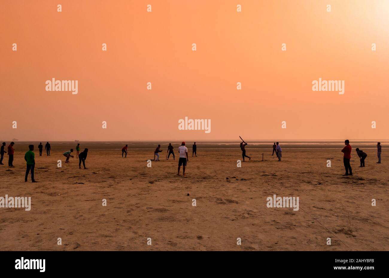 Silhouette Of People , Playing Cricket at the Time of Sunset on a Beach. Stock Photo