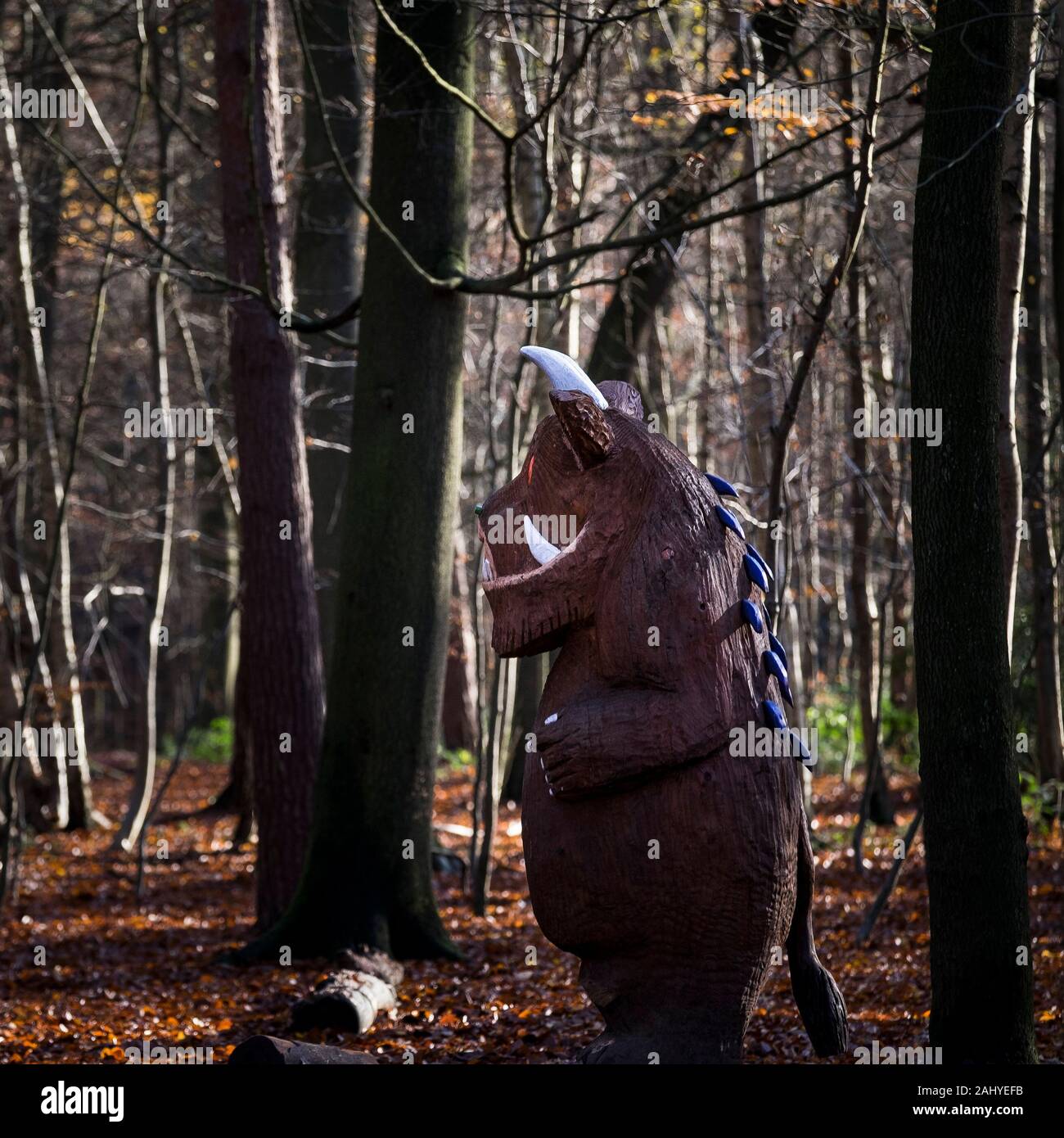 A wooden carved statue of The Gruffalo in an autumnal Thorndon Park North in Brentwood in Essex. Stock Photo