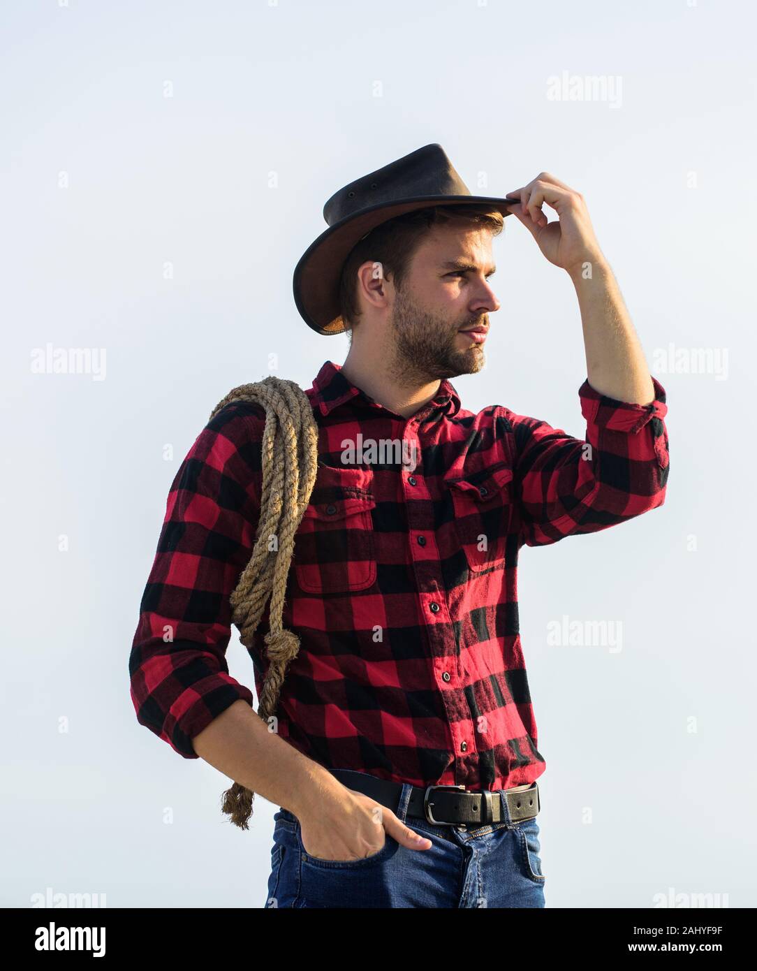 Ranch worker. Life at ranch. Cowboy with lasso rope sky background. Eco ...