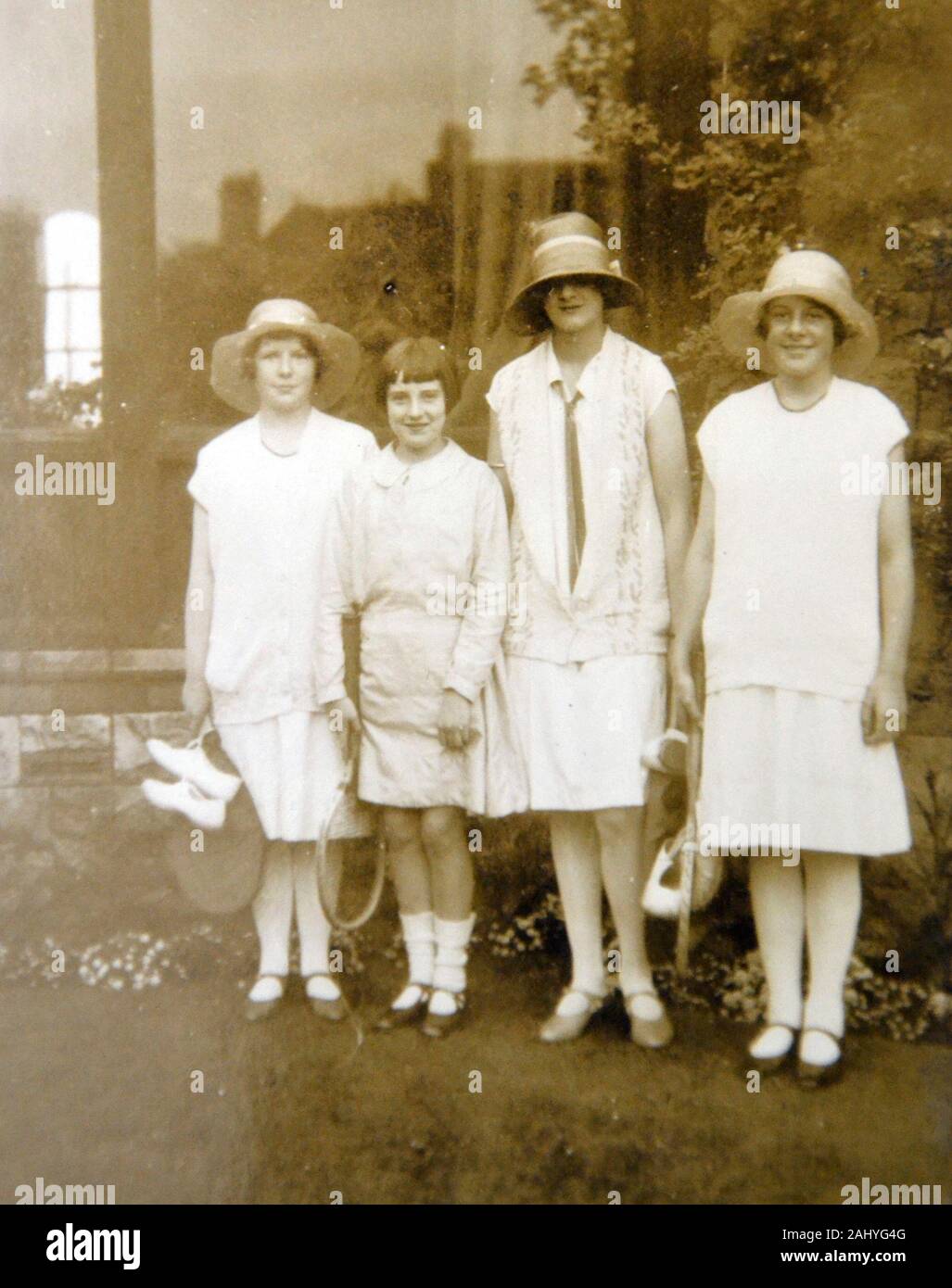 Old vintage black and white photograph of a group of women and girls standing in a garden looking at the camera Stock Photo