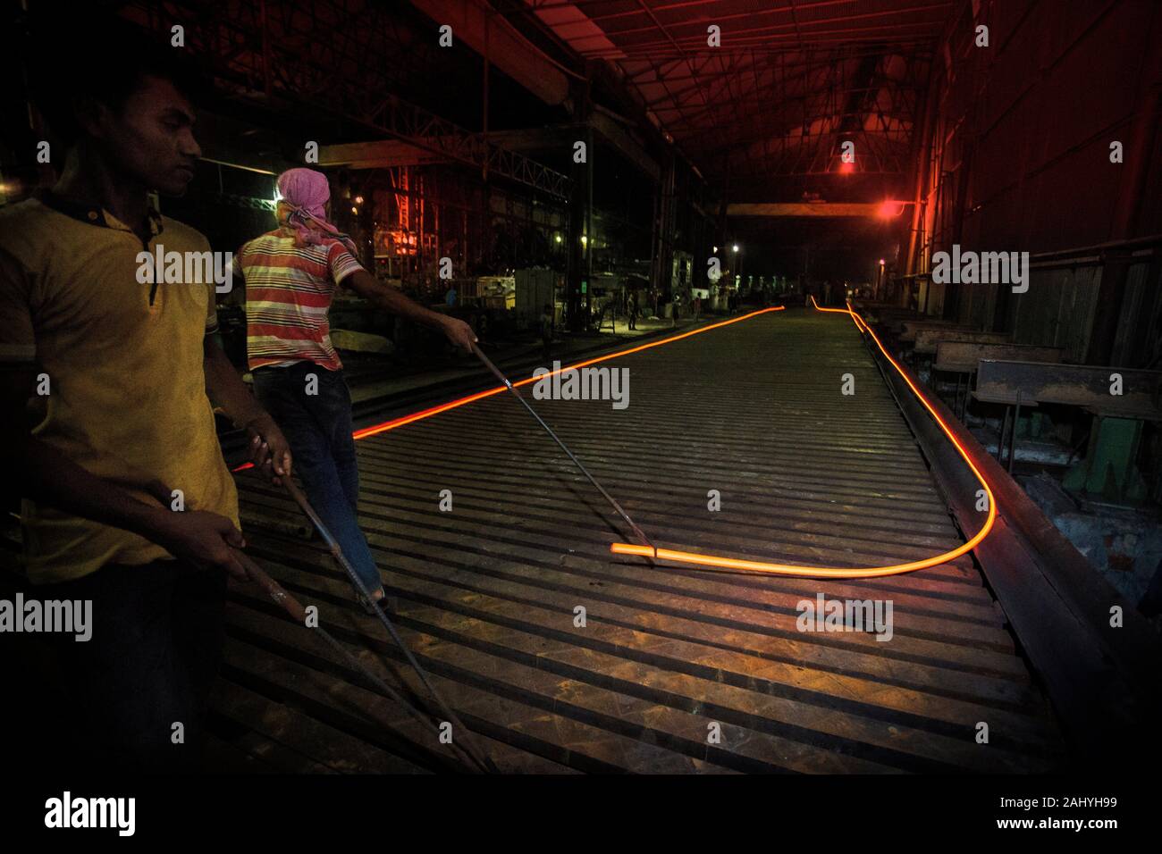 Bangladesh.Heated metal gets squeezed and running, risky workers in steel factories are working at Demra, Dhaka, Bangladesh. Stock Photo