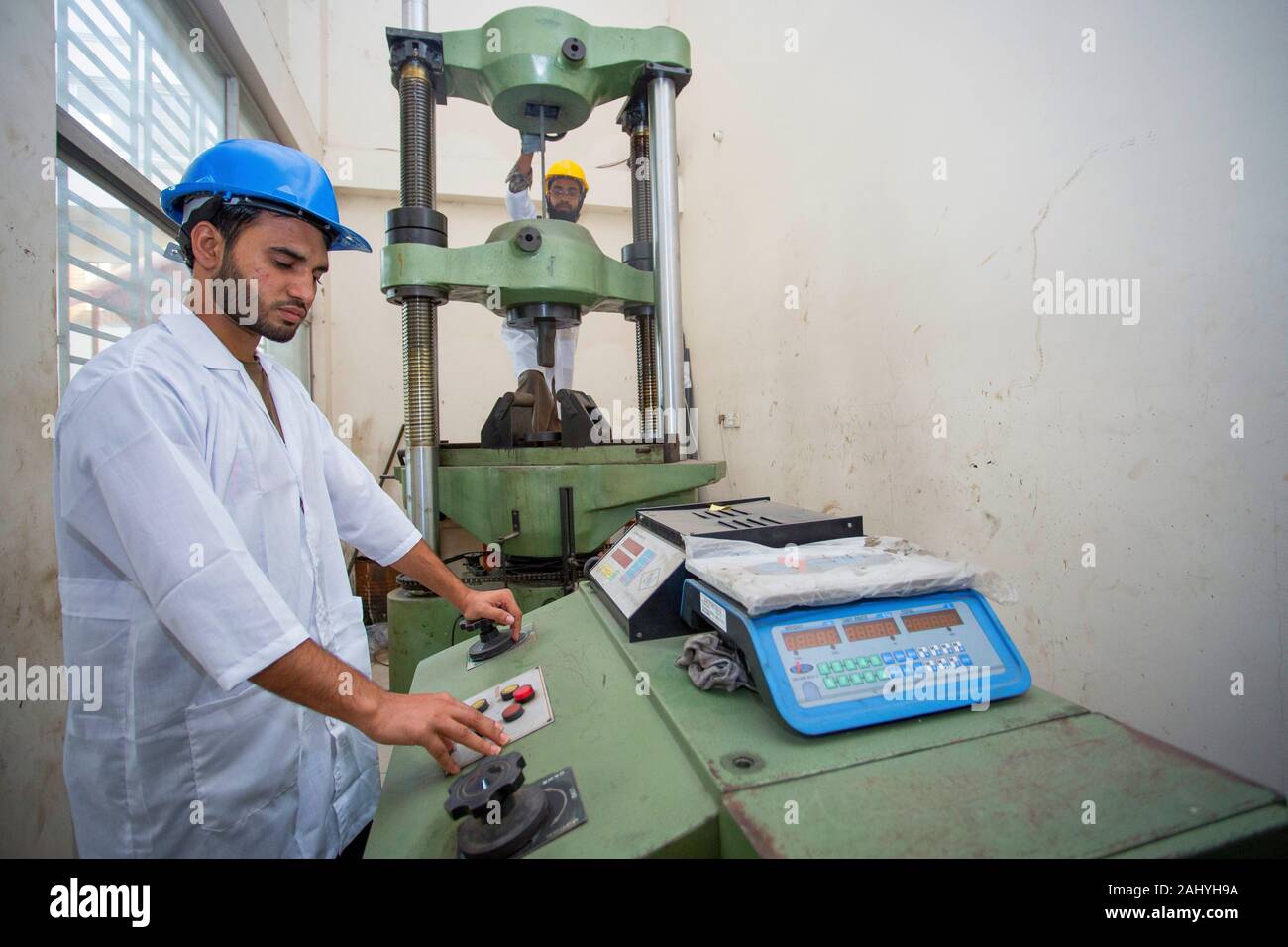 Bangladesh.A factory lab operator using Steel rod strength testing