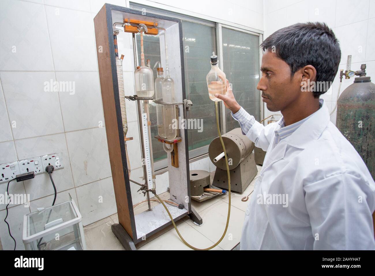 A factory lab operator using Steel rod quality testing machine at Demra