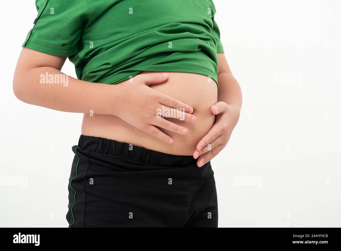 Asian little boy with stomach ache, child holding his hands on his belly. Stomach ache child stock image. Stock Photo