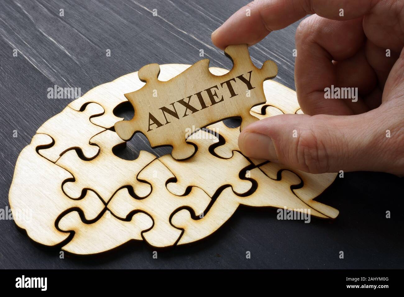 Anxiety. Hand holds on part of puzzles from brain. Stock Photo
