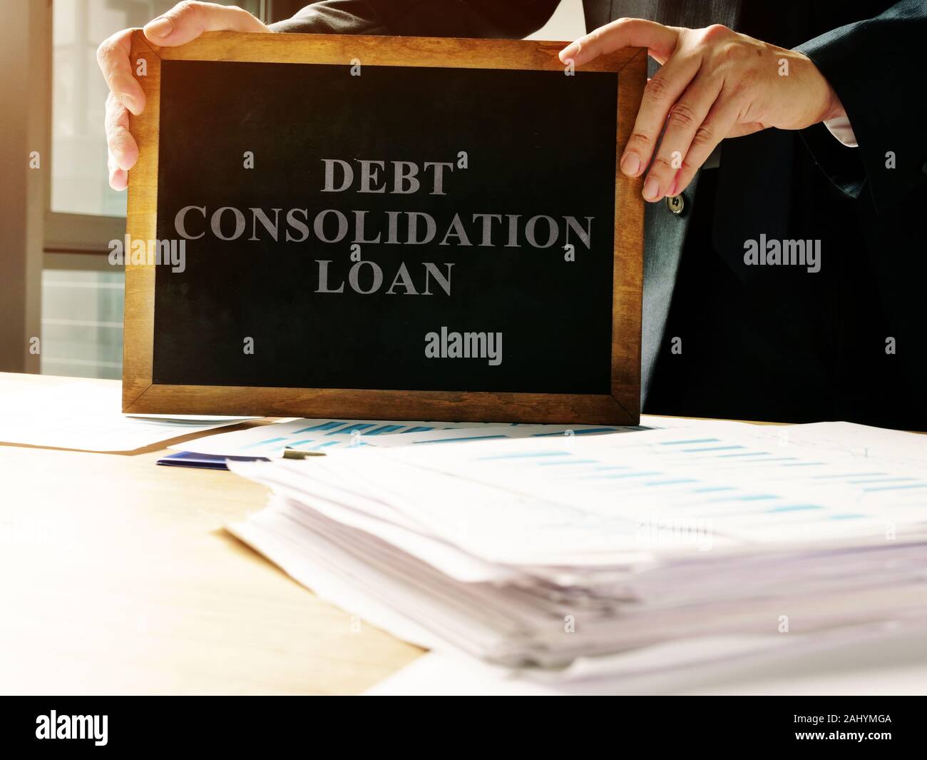 Debt consolidation loan sign and pile of papers. Stock Photo