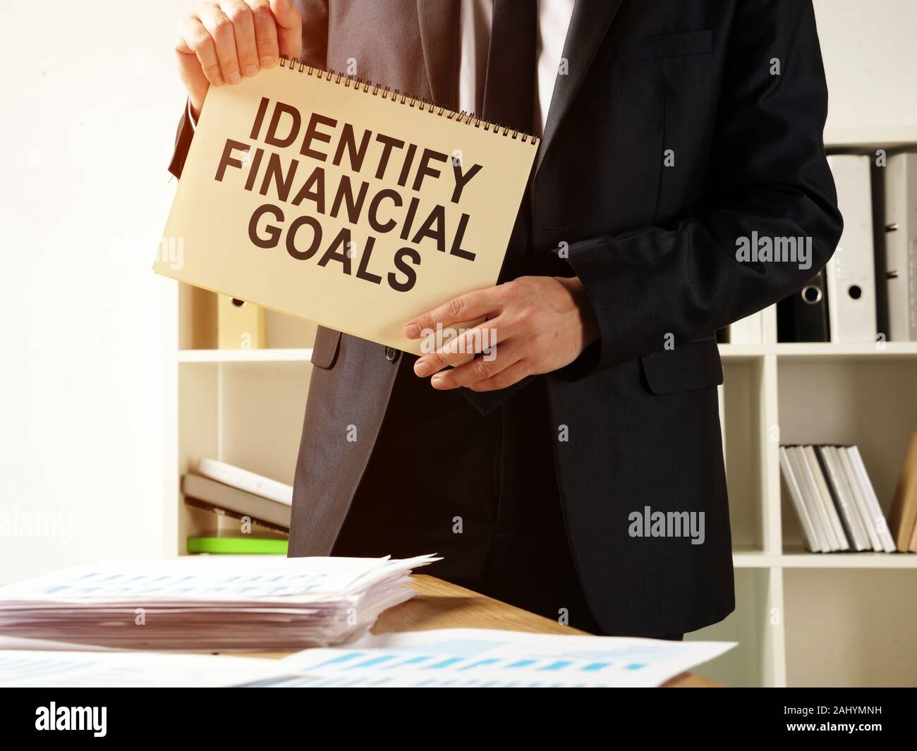 The consultant holds the inscription Identify financial goals. Stock Photo