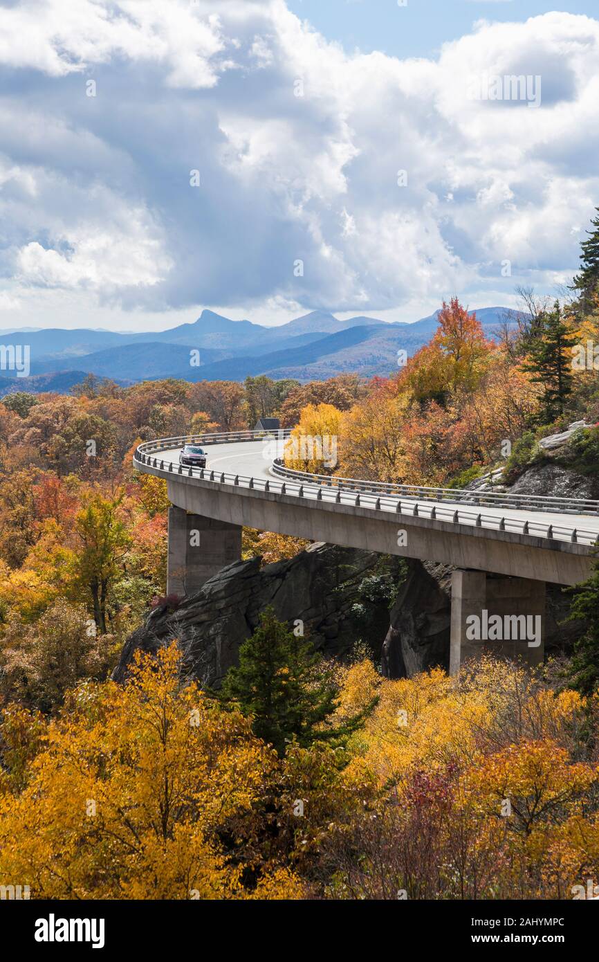 Car drives over Linn Cove Viaduct, Blue Ridge Parkway in the Fall, NC Stock Photo