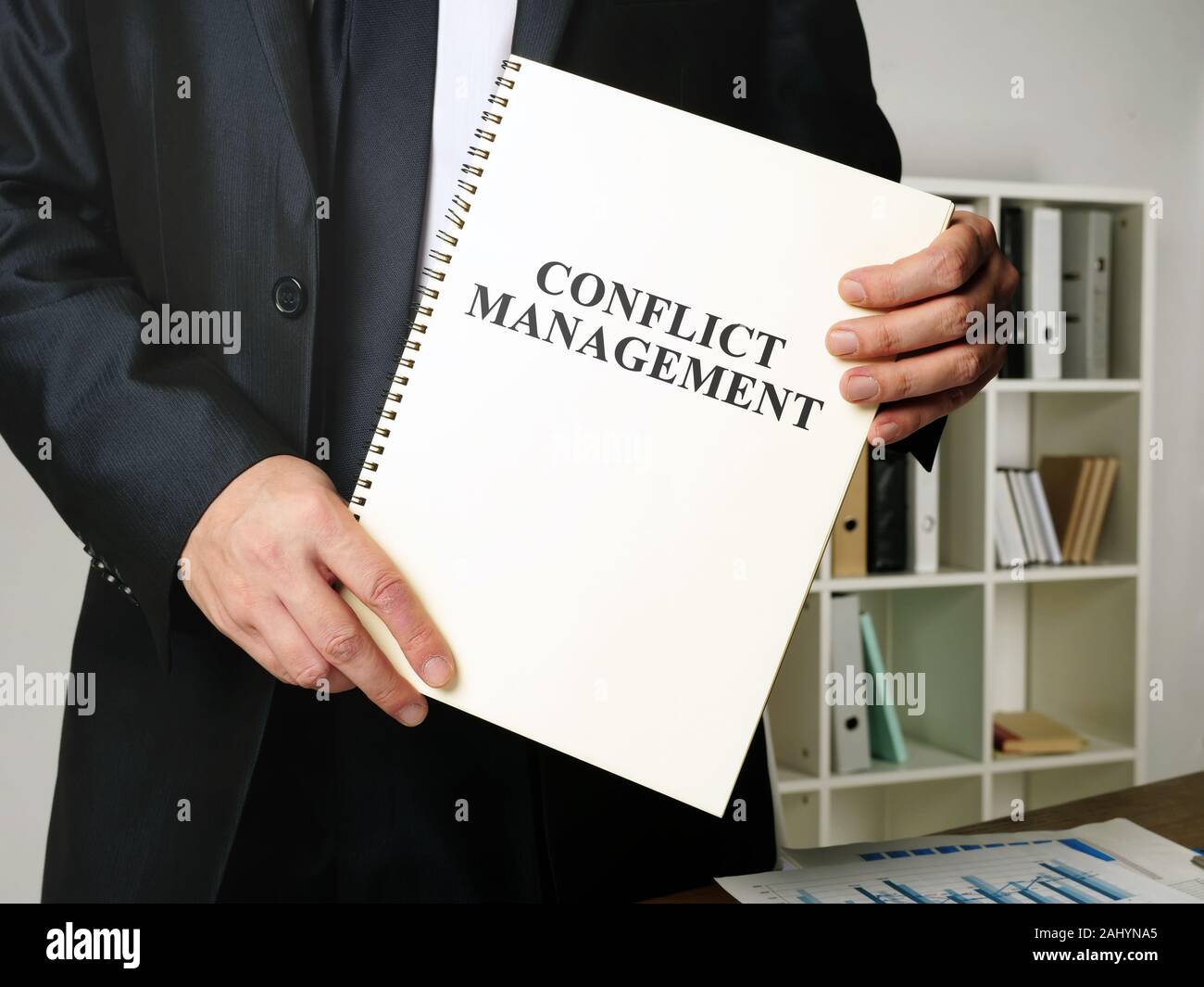Conflict Management book in the hands of the manager. Stock Photo