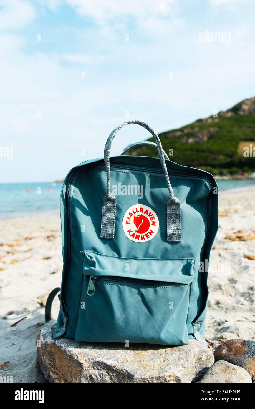 TARRAGONA, SPAIN - SEPTEMBER 16, 2018: A popular Fjallraven Kanken backpack on a rock, on a quiet beach in Tarragona, Spain. This is the best-selling Stock Photo
