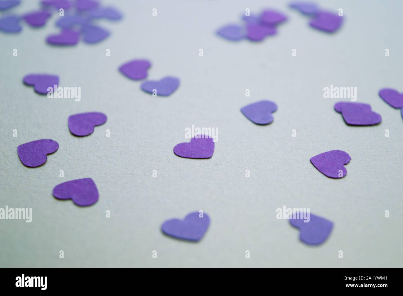 Tiny purple hearts on the golden background for St. Valentines Day 2020. Holiday mood. Stock Photo